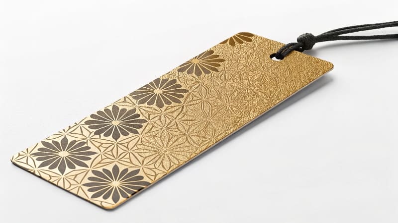 A close-up of a bookmark showing the texture of gold foil stamping and [spot UV](https://wansapackaging.com/what-are-some-creative-bookmark-ideas/)<sup id=