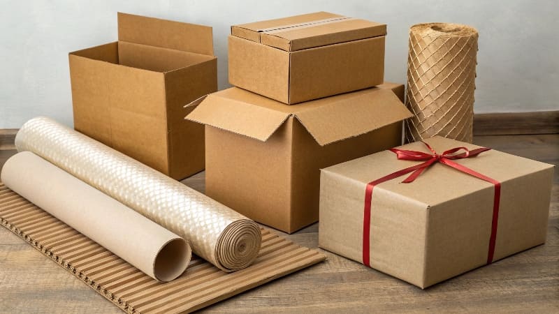 Different Types of Cardboard A stack of various types of cardboard, including corrugated and paperboard sheets.